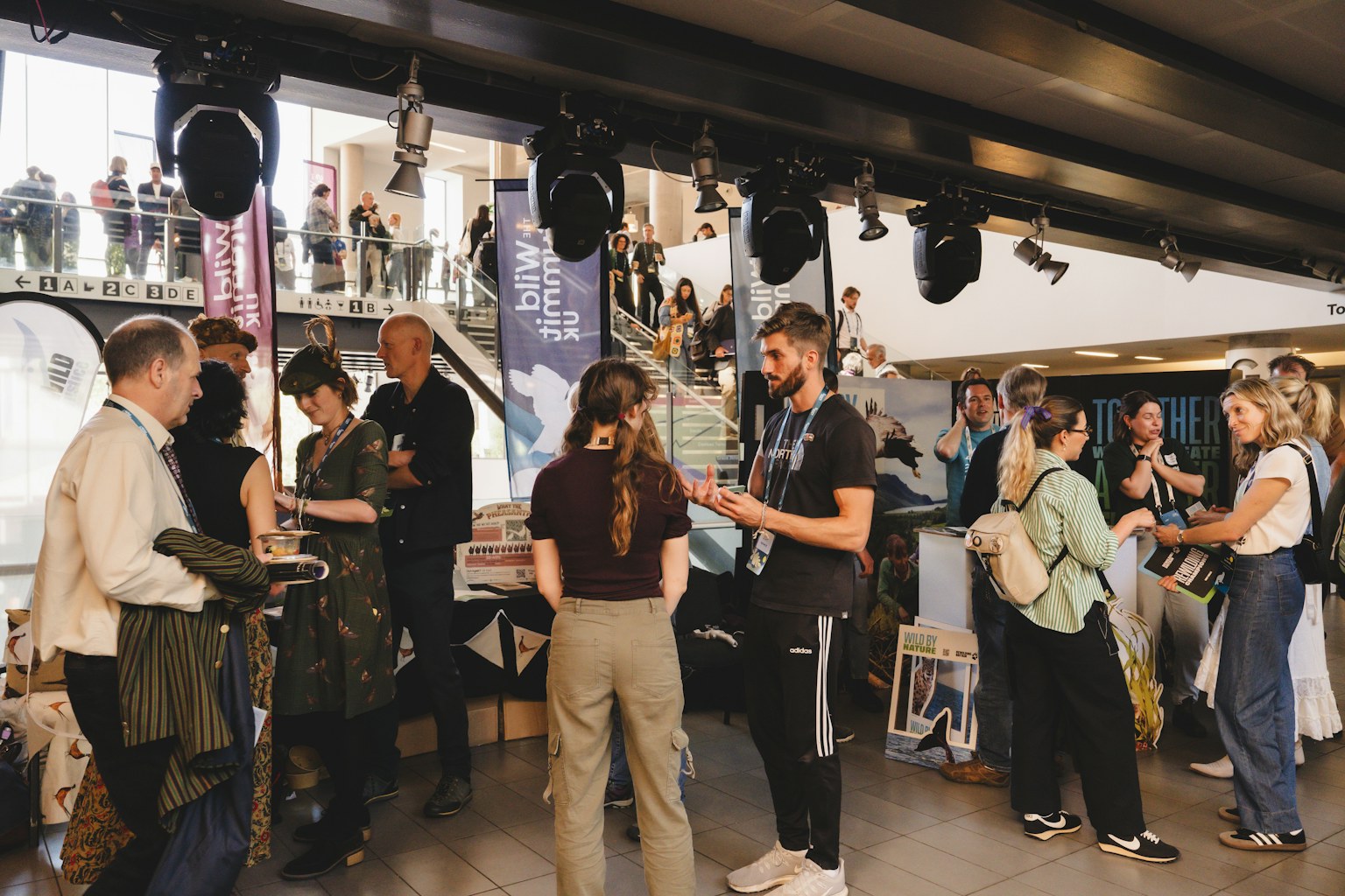 Photo of people milling around nature organisation stands at the Wild Summit event in Bristol