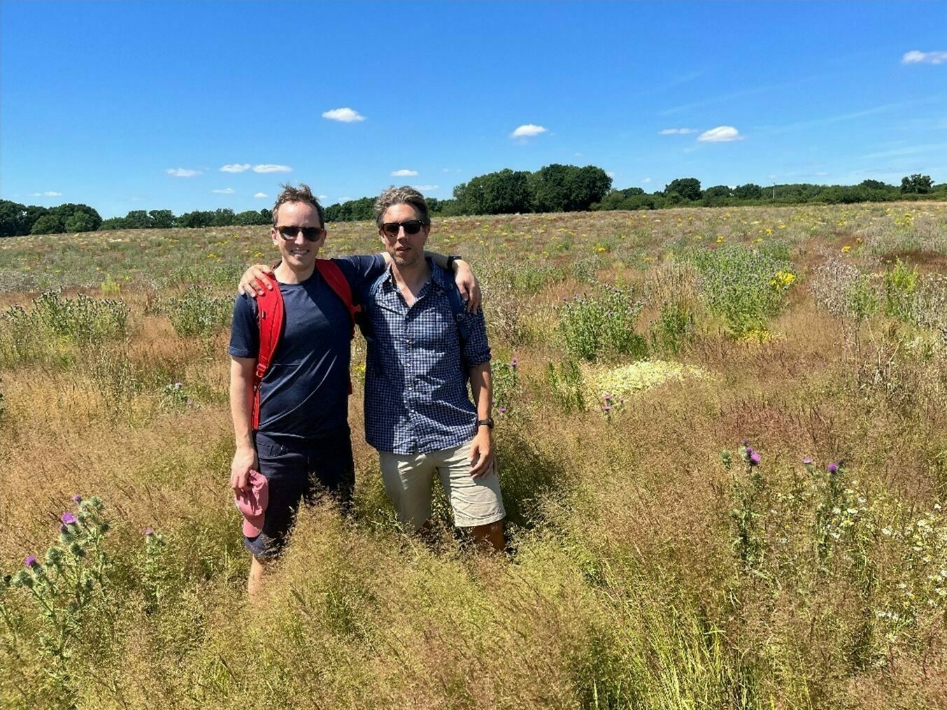 Ed Heaven and Cedric Durant des Aulnois standing in a grassland landscape