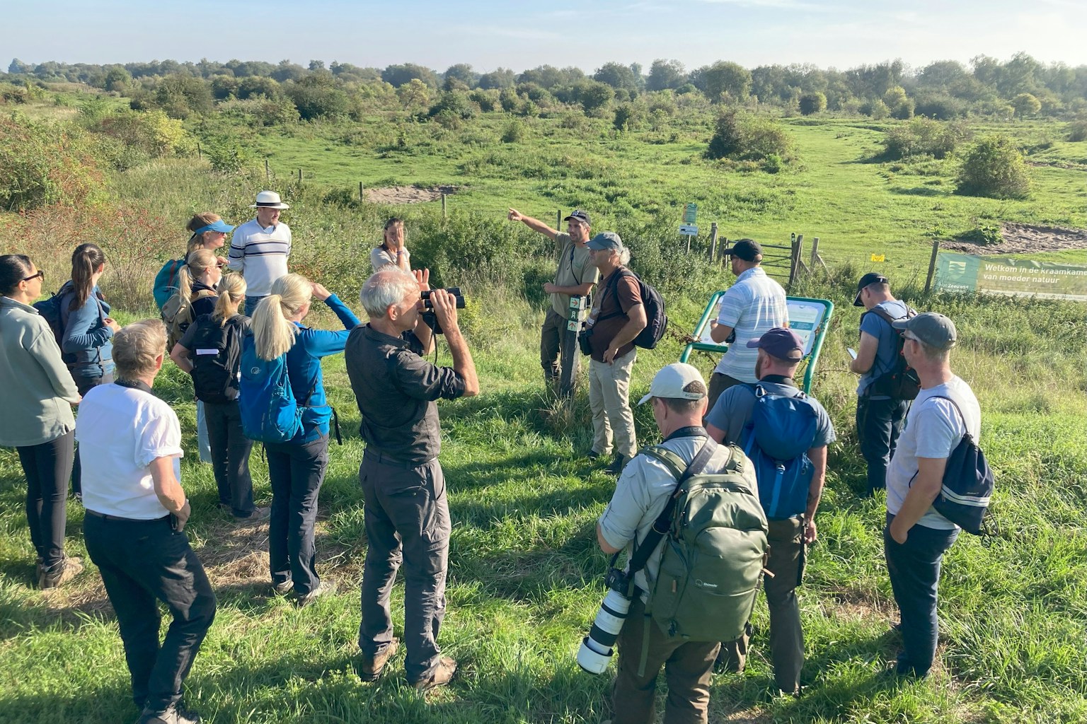 The Kent Widlife Trust team stand in a circle, being given an intro to Slikken van de Heen, a nature reserve in the Netherlands