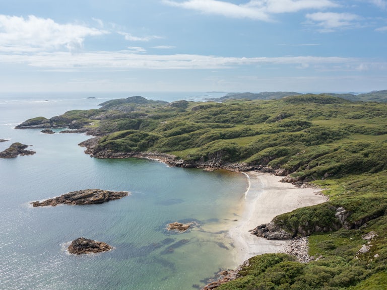 A beach and scrub woodland spanning the coastline surrounding Northwoods Rewilding Network partner, Tieregan.