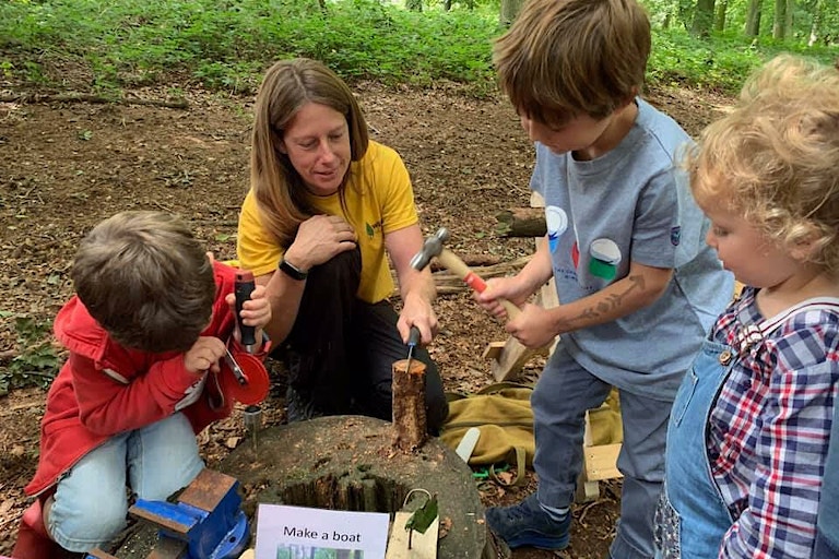 Children in a 'make a boat workshop' in the woods