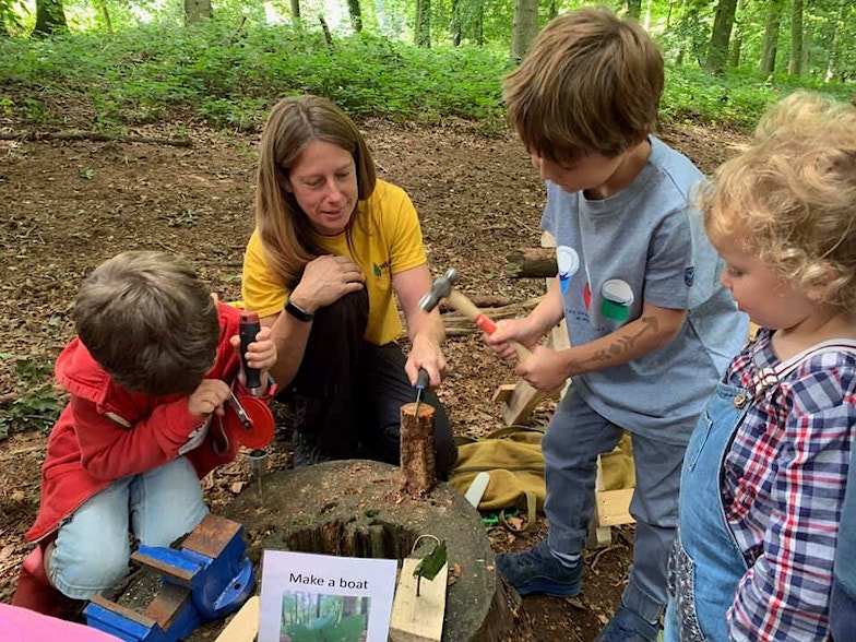 Children in a 'make a boat workshop' in the woods
