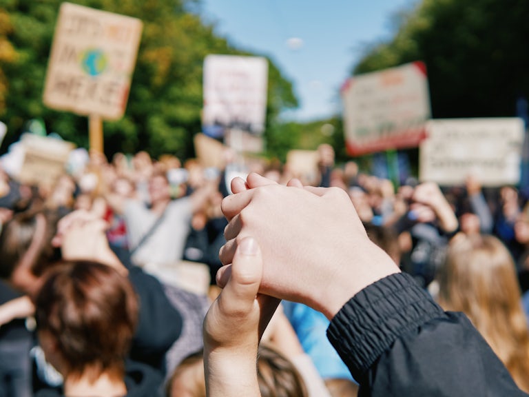 Close up of clasped hands at climate protest