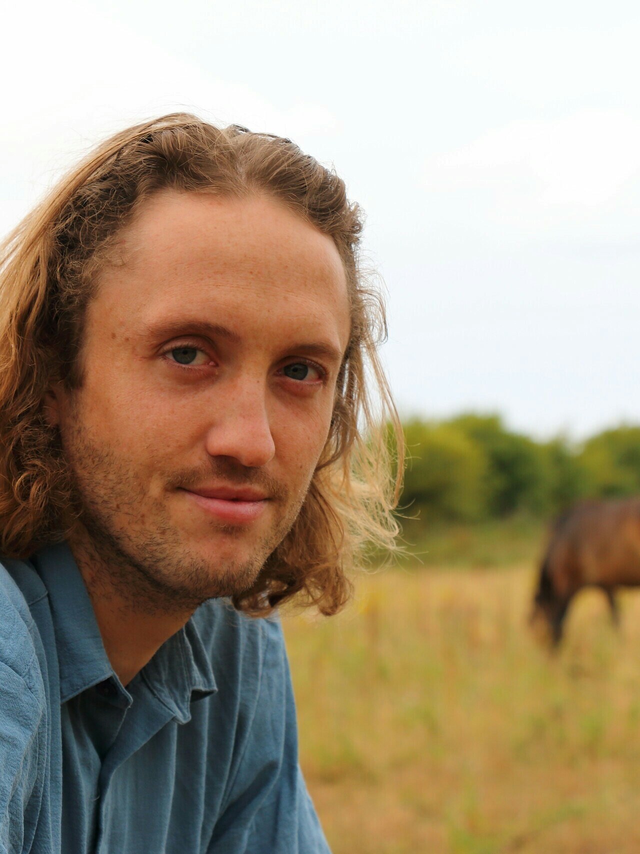 Dominic Buscall with a pony in the background at Wild Ken Hill