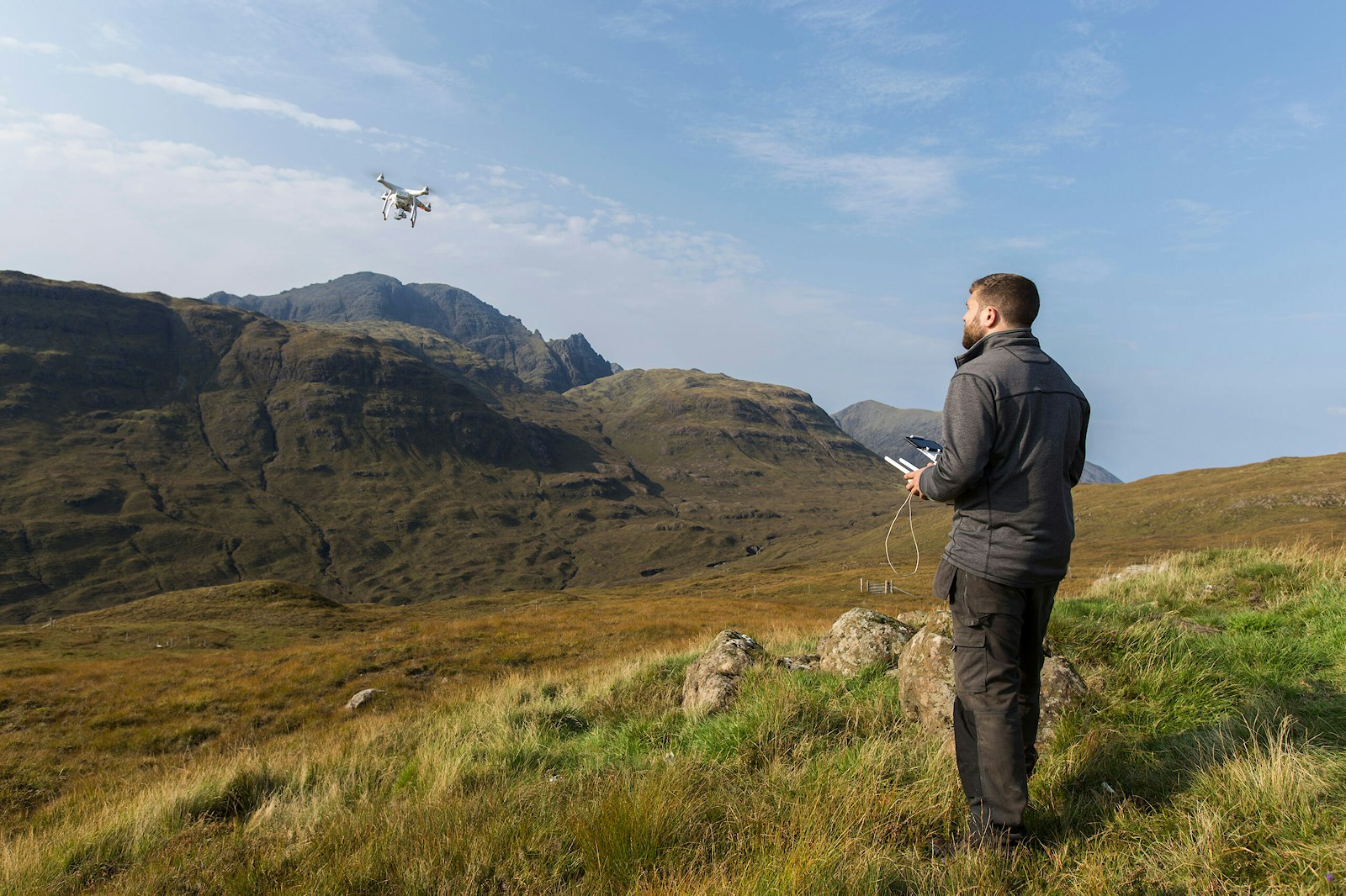Pilot flying DJI Phantom drone over Blaven, Isle of Skye, Scotland