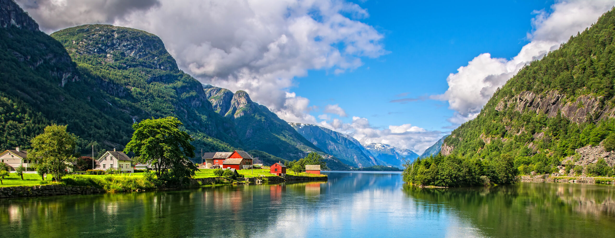 Norway lake with house and woodland growing up trees.