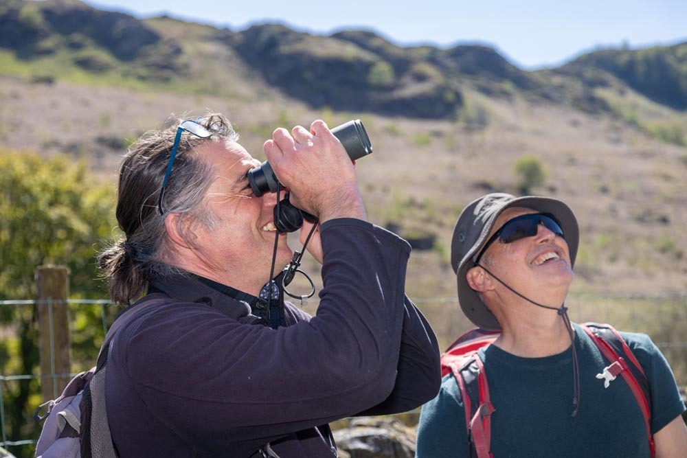 Men with binoculars at rewilding gathering at Wild Haweswater