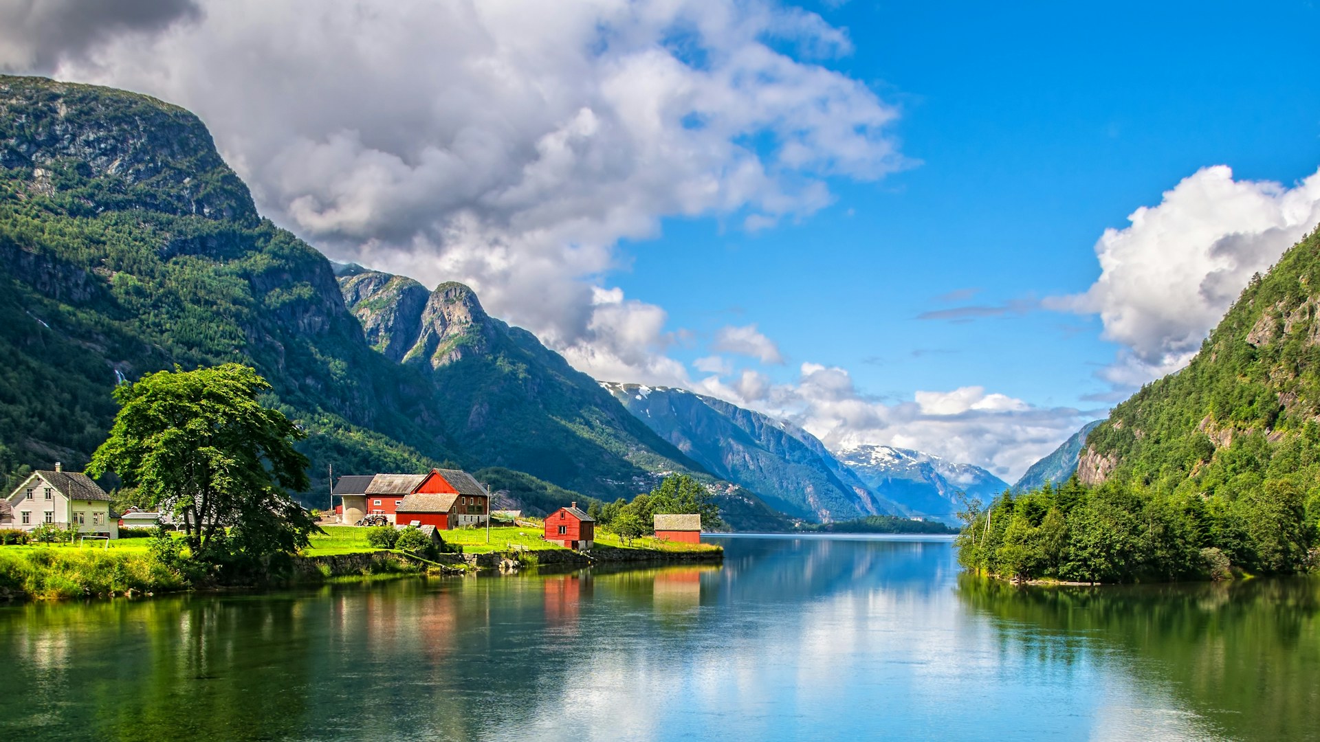 Norway lake with house and woodland growing up trees.