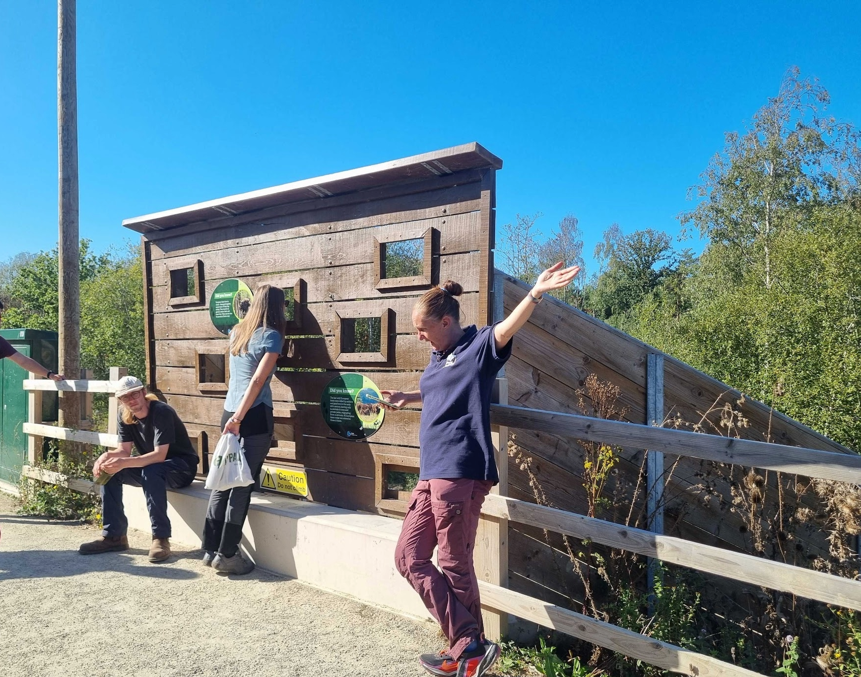 Staff member and visitors standing on a bison bridge with a viewing hide at Wilder Blean